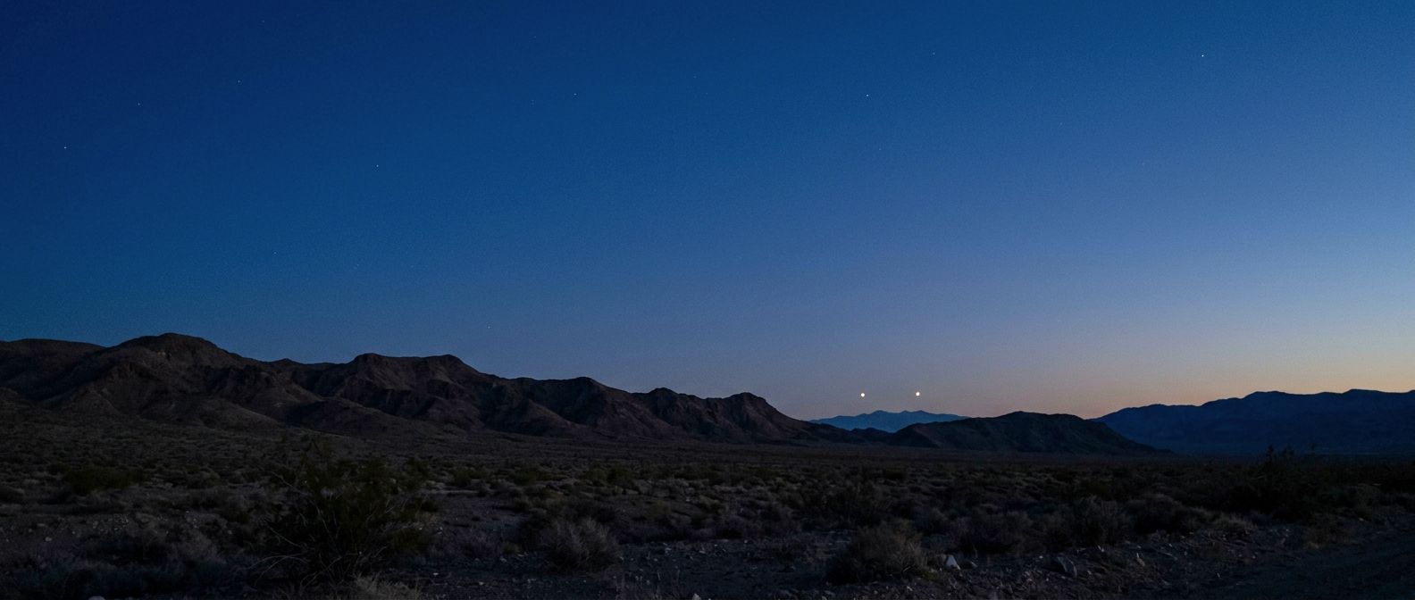 Two unexplained lights over a western US desert ridgeline at dusk